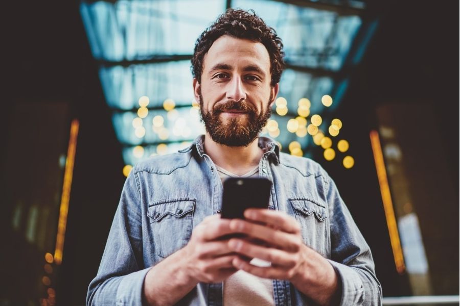 it expert with beard an phone smiling