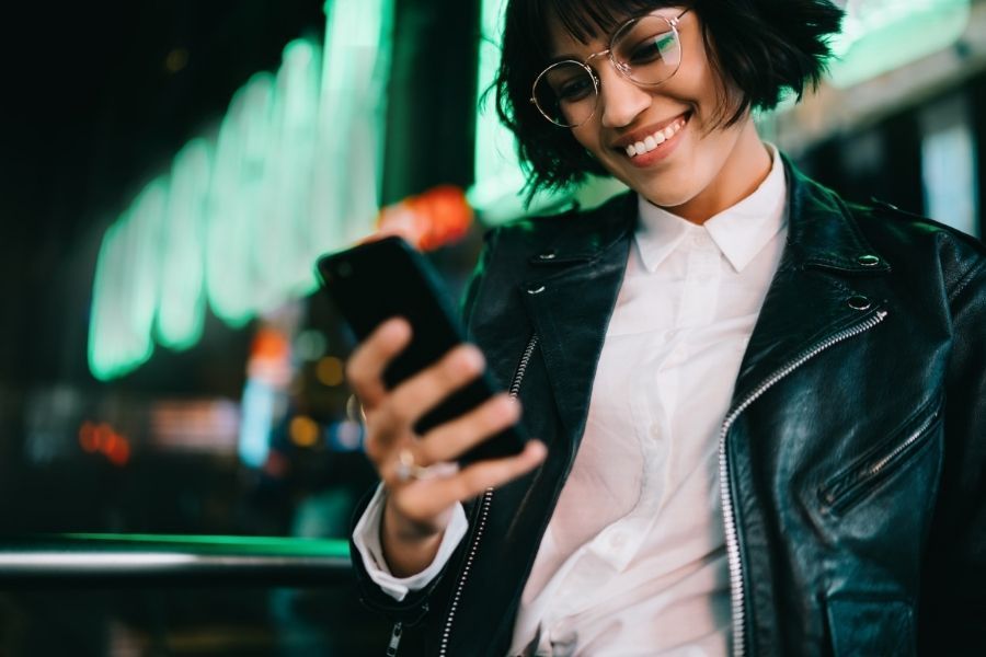 young tech expert at night with her phone