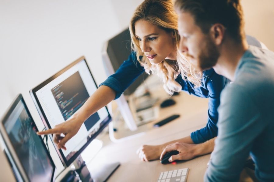 female it expert explains code solutions to new colleague