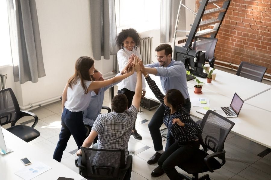 Mitarbeiter geben sich high five im Büro