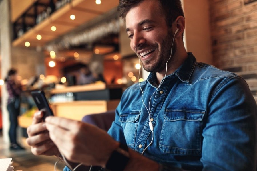 young thech expert in cafe with mobile phone on a video call